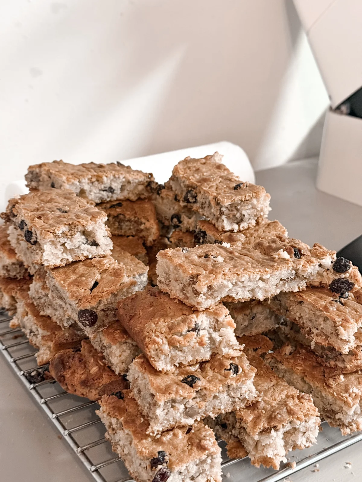 Homemade seed and cranberry rusks stacked on a cooling rack